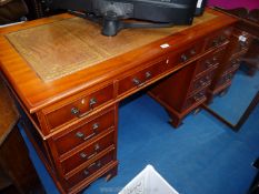 A reproduction desk with brown leather insert, 48'' wide x 23 1/2'' deep x 30'' high.
