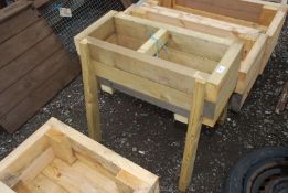 A raised wooden planter 27'' x 11 1/2''.