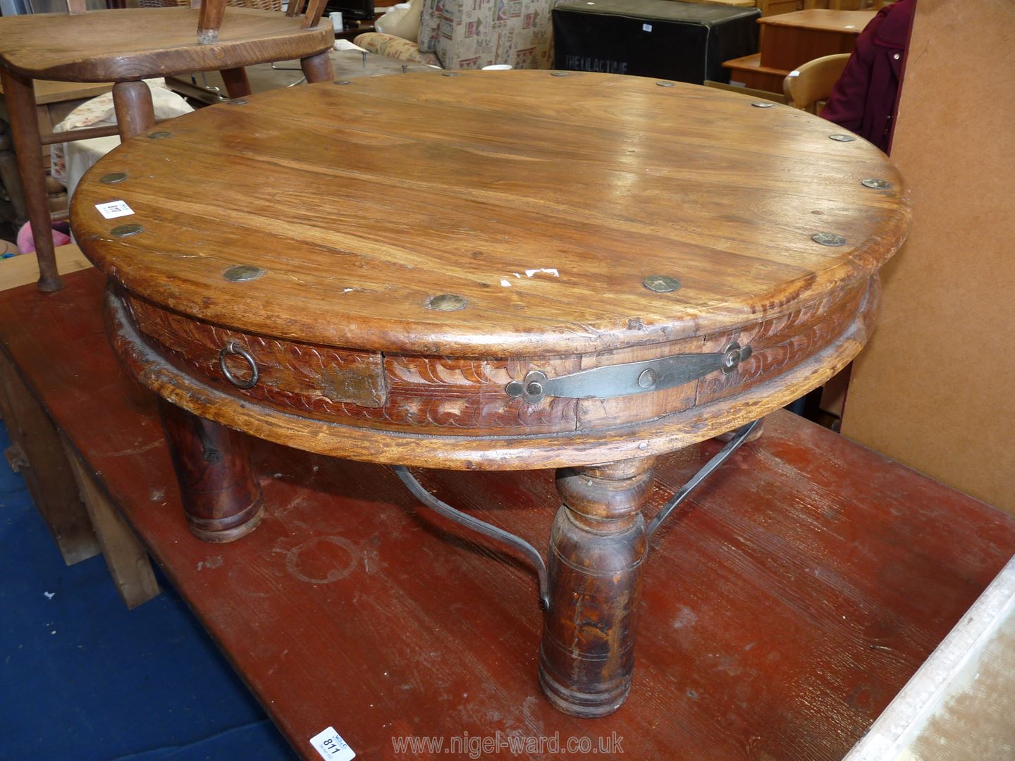 A rustic carved wood circular lounge table with drawers, 29'' diameter x 16'' high.