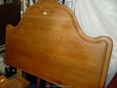A carved pine double headboard.