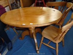 An oval pine pedestal dining table and four chairs,33'' wide x 47'' long.