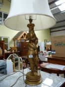 A cherub style table lamp with large shade.