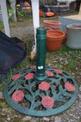 A large metal umbrella stand with rose design.