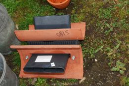 A pair of clay and plastic roof vents.