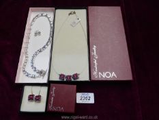 A modern white metal necklace and earrings and a Noa hand-made necklace and earrings set.