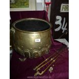 A brass coal scuttle and three fire irons including tongs and two pokers,