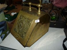 A brass Coal Scuttle with sunflower detail to the front, with shovel, a/f.