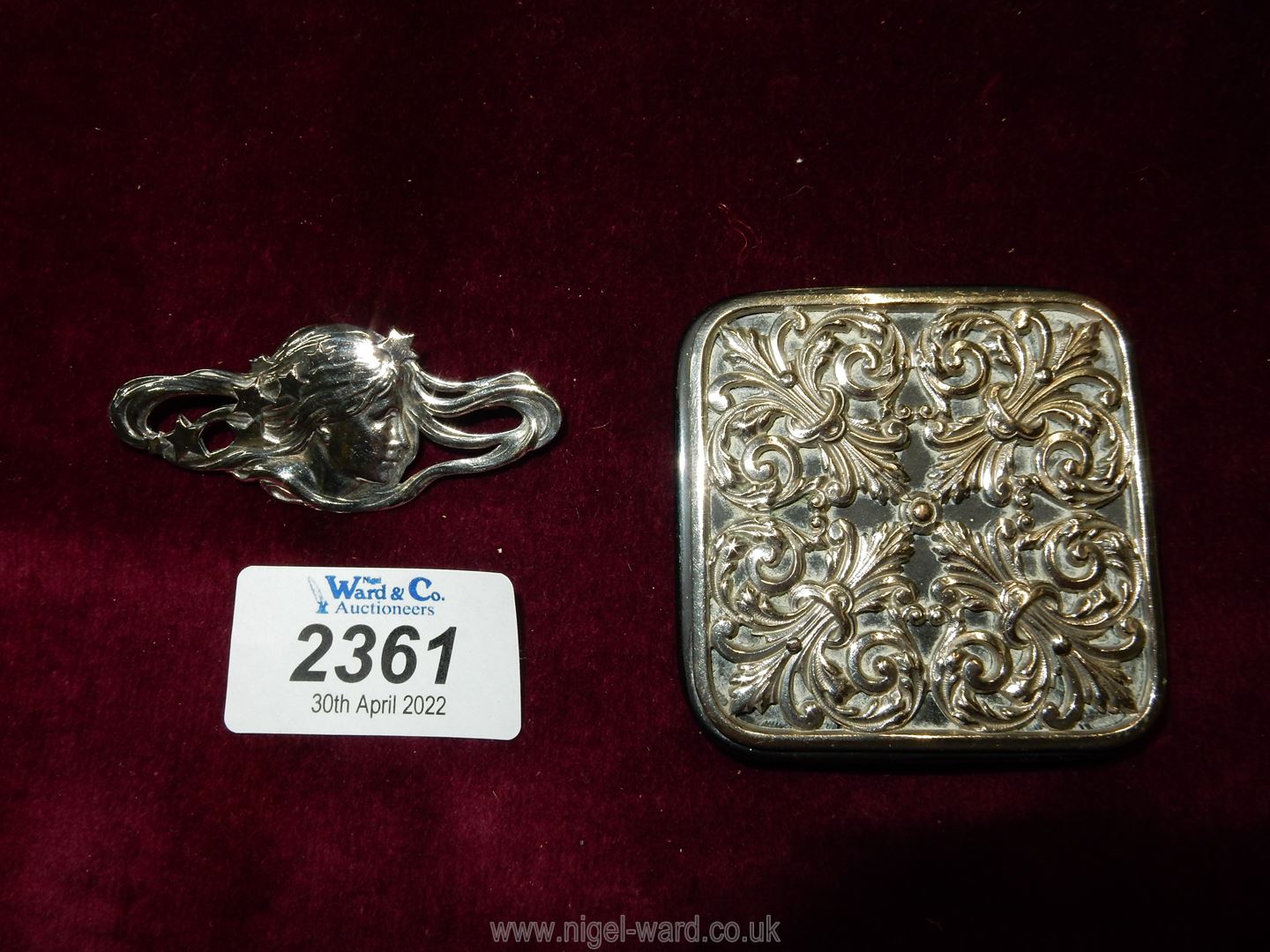 A white metal belt buckle and Art Nouveau style brooch with Virgo detail.