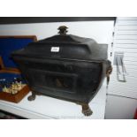A metal log box with lid having lion handles,