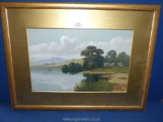 A framed and mounted painting of a river landscape with rolling hills in the distance,
