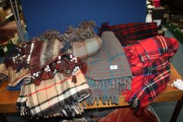 A quantity of travel rugs in tartan patterns including blue & grey, beige, etc.