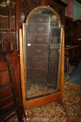 A large Cheval mirror, arched, having green inlaid border, (some damage to veneer), on castors,