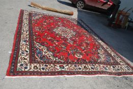 A large red blue and cream grouind, bordered, patterned and fringed Carpet, 148'' x 107''.