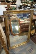 A large ornate gilt framed bevel edged wall Mirror with raised detail to the corners and scalloped