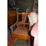 A satinwood framed open armed Commode Armchair having a caned seat,