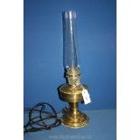A Brass oil lamp with glass chimney, converted to electric, 23 1/4'' tall overall.