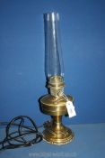 A Brass oil lamp with glass chimney, converted to electric, 23 1/4'' tall overall.