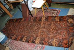 A long burgundy/orange ground bordered, patterned and fringed Runner, worn, 102'' x 37''.