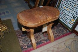 A lightwood Footstool with the emblem of The Royal Horse Artillery carved into the top,