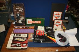 A box of games including Scrabble, Mastermind, Chess pieces, Monopoly, etc.