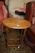 An oval light Oak occasional Table standing on twist legs united by a perimeter stretcher,