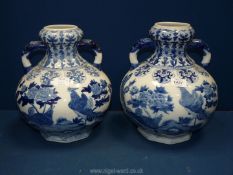 A pair of blue and white two handled Oriental bulbous Vases with scenes of birds, 12 1/2" tall.