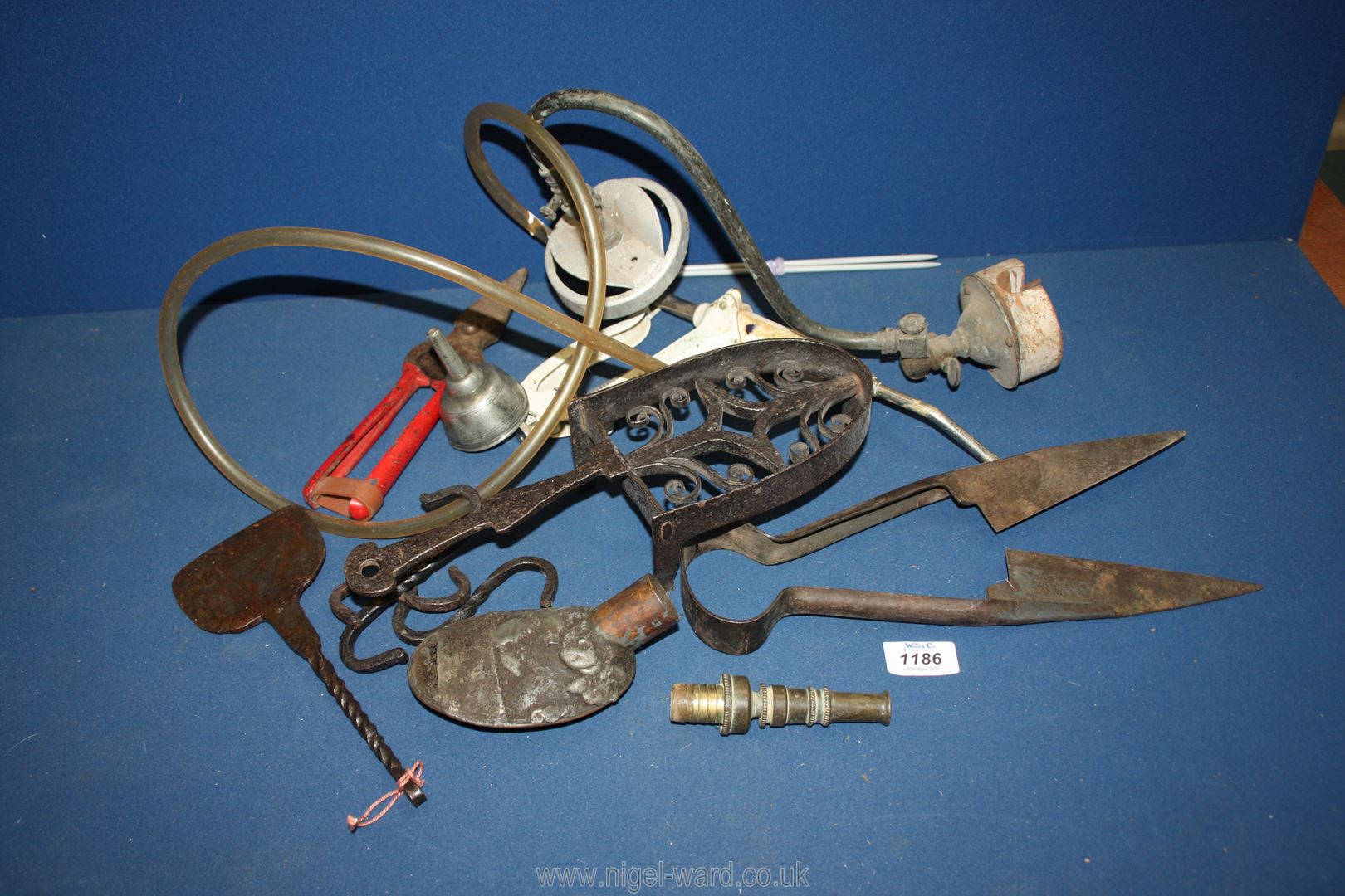 A quantity of metal items including shearing clippers, trivet, watering can spout, etc.