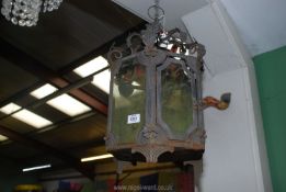 A metal hanging Lantern with green tinted glass panels.