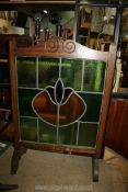 A wooden framed stained glass fire guard.