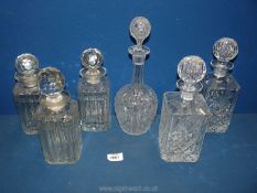 Six decanters including five square and a dumpy shaped decanter all with stoppers.