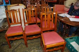 A set of six Oak framed dining chairs having deep pink upholstered drop-in seats.