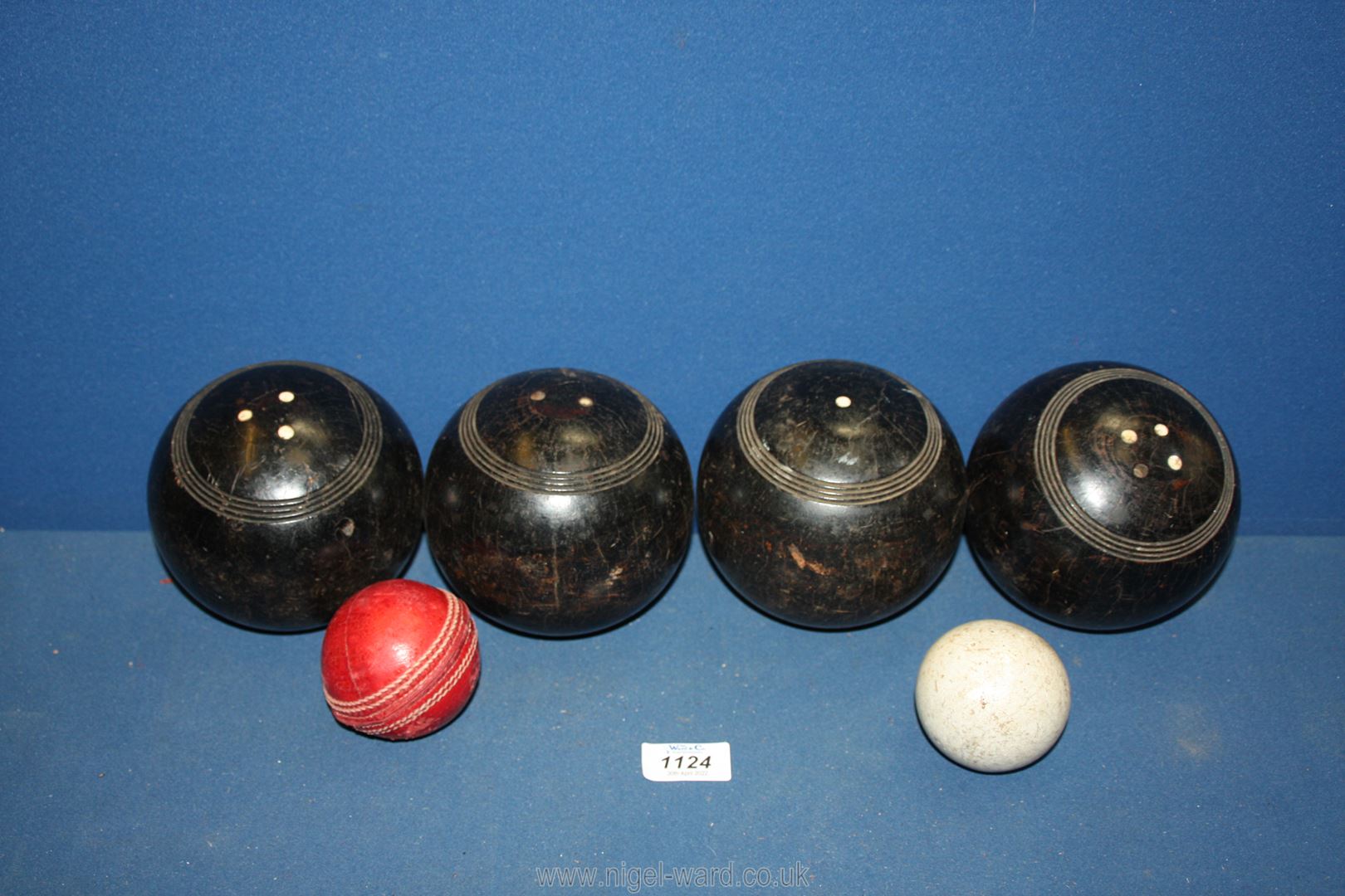 Four Bowling balls and a jack (used condition) and a cricket ball.