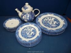 A quantity of Royal Norfolk willow pattern plates and a similar patterned Churchill teapot.