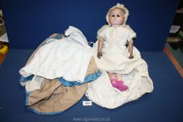 A wax over papier mache doll, articulated hands, jointed and with original clothes, no eyes.