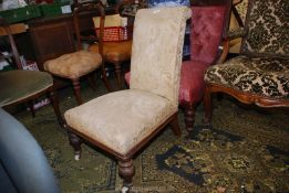 A Mahogany framed beige shadow pattern upholstered Nursing Chair having turned and carved front