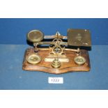 A brass and wood Postal Scales with weights, 7'' x 5'' tall.