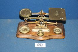A brass and wood Postal Scales with weights, 7'' x 5'' tall.