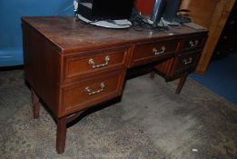 A "G-Plan" teak finished Dressing table/Desk having five drawers with brass finished drop handles