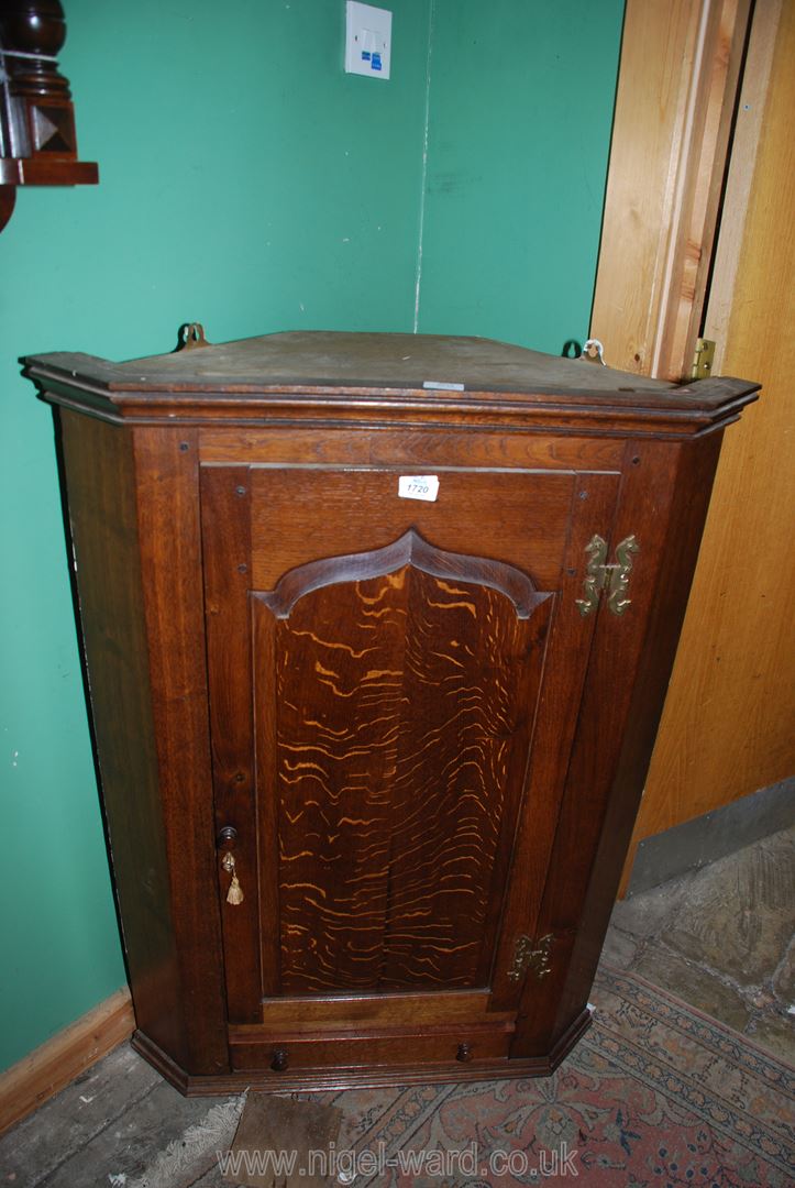 An Oak wall hanging Corner Cupboard, the shaped,