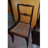 A Mahogany framed Chair, stained to simulate rosewood and having a caned seat and sabre legs,