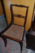 A Mahogany framed Chair, stained to simulate rosewood and having a caned seat and sabre legs,