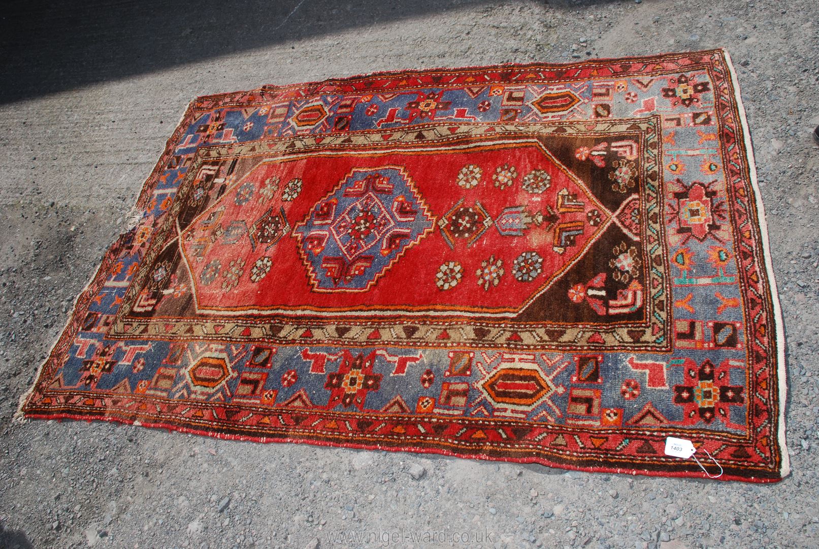A bordered and patterned Rug, some fading and damage, 79'' x 54''.