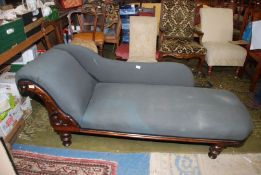 A circa 1900 darkwood framed Chaise Longue upholstered in dark grey fabric and standing on turned