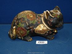 An oriental pottery cat heavily decorated with raised flowers and with a gilded collar and tail,