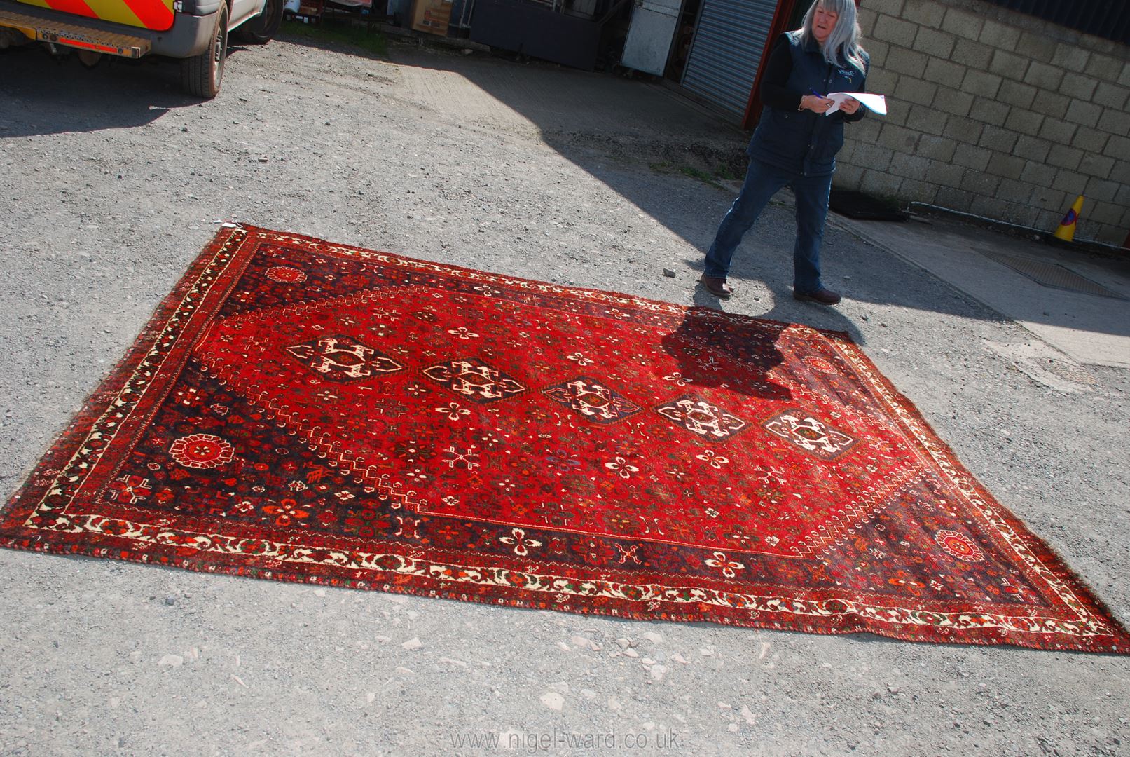 A large burgundy, navy and cream bordered, patterned and fringed Carpet, made in Iran, 120'' x 90''.