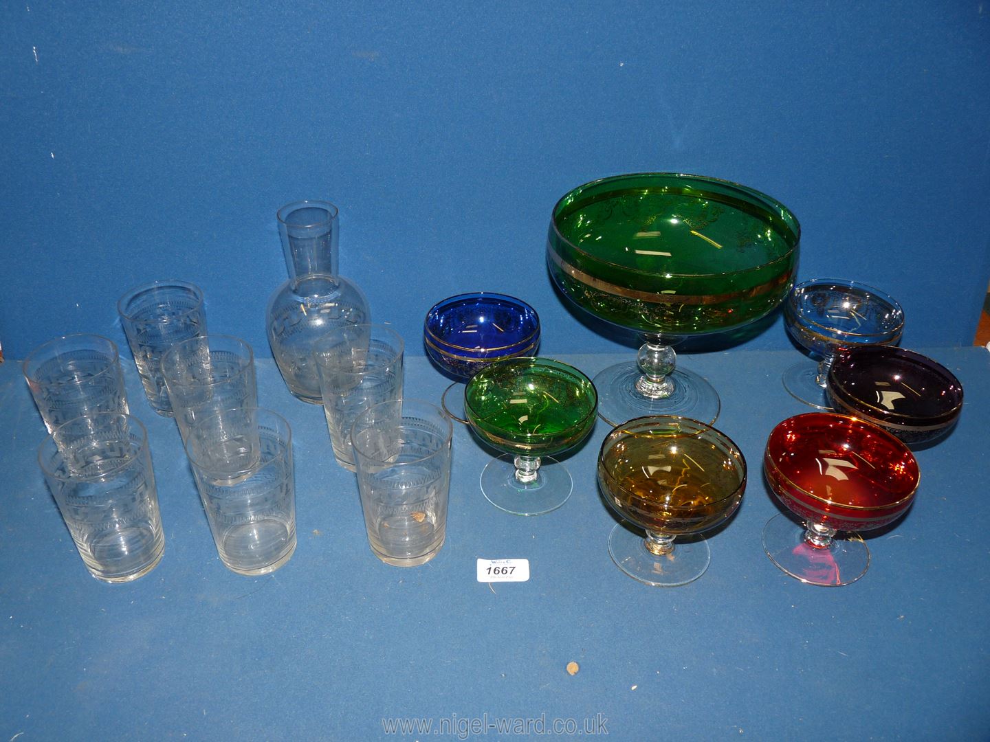 An etched water set of seven glasses decanter together with a coloured glass fruit set