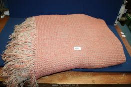 A single Welsh Wool waffle weave Blanket in pink and beige.