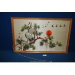 A Japanese embroidered picture on silk depicting Cranes in a tree at sunset.