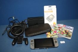 A Nintendo Switch with five games, charger plug, case protector, charging station,