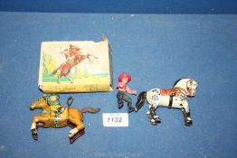 A boxed Japanese clockwork toy 'King of The Rancher' by Alps and a tinplate horse and rider.